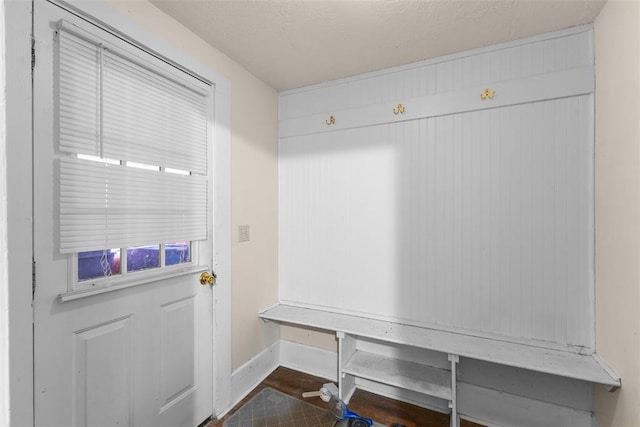 mudroom featuring a textured ceiling, wood finished floors, and baseboards