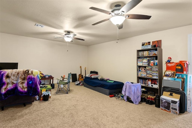 game room featuring a textured ceiling, carpet floors, visible vents, and a ceiling fan