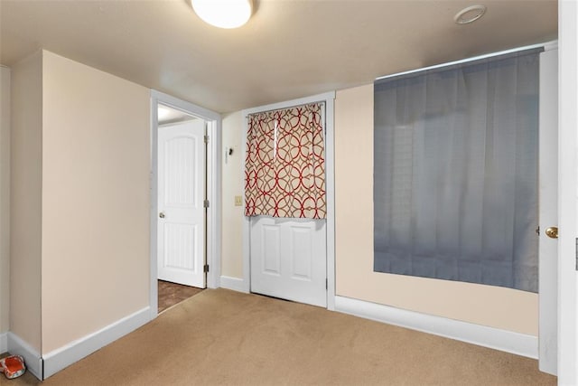 unfurnished bedroom featuring carpet and baseboards