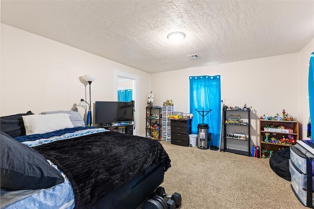 bedroom with carpet flooring, visible vents, and a textured ceiling