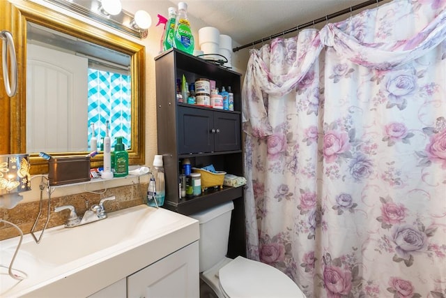 bathroom featuring toilet, curtained shower, and vanity