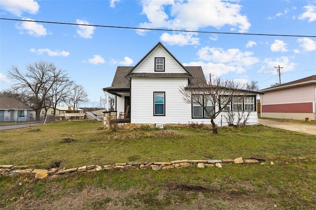 exterior space with roof with shingles and a front yard