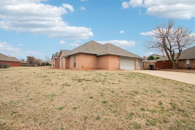 view of home's exterior with a yard, concrete driveway, brick siding, and an attached garage