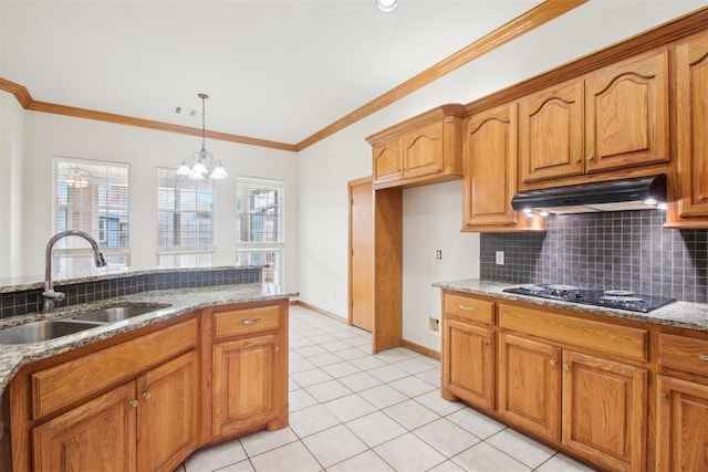 kitchen with decorative backsplash, light stone counters, black electric cooktop, under cabinet range hood, and a sink