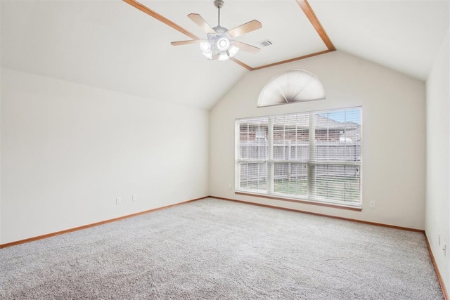 carpeted empty room with vaulted ceiling, baseboards, visible vents, and a ceiling fan