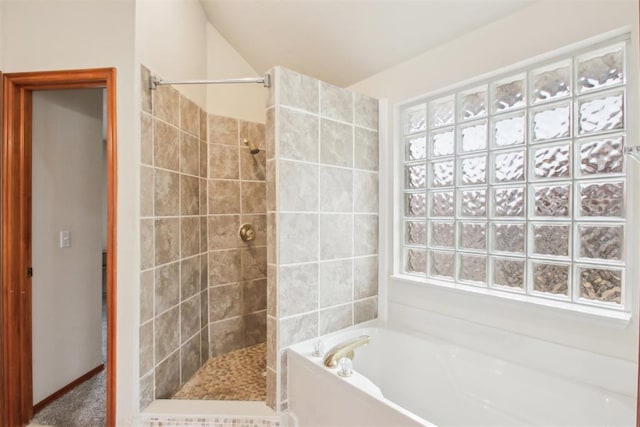 bathroom featuring a walk in shower and a bath