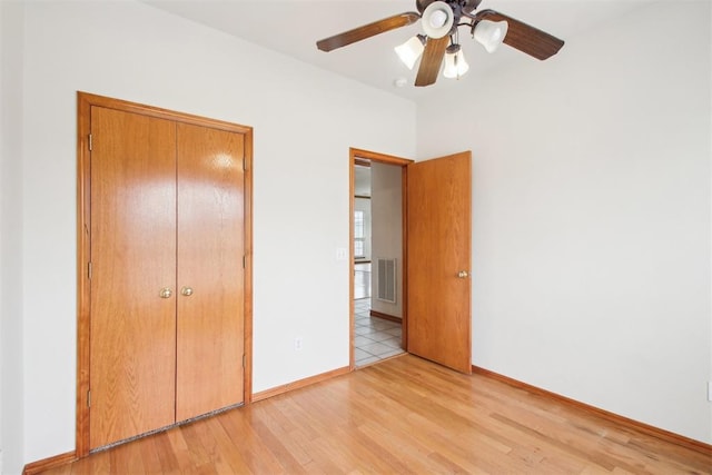 unfurnished bedroom featuring visible vents, ceiling fan, light wood-style flooring, and baseboards