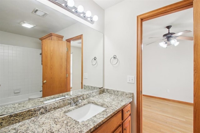 bathroom with ceiling fan, wood finished floors, vanity, visible vents, and baseboards