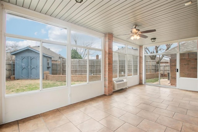 unfurnished sunroom featuring ceiling fan, wooden ceiling, and a healthy amount of sunlight