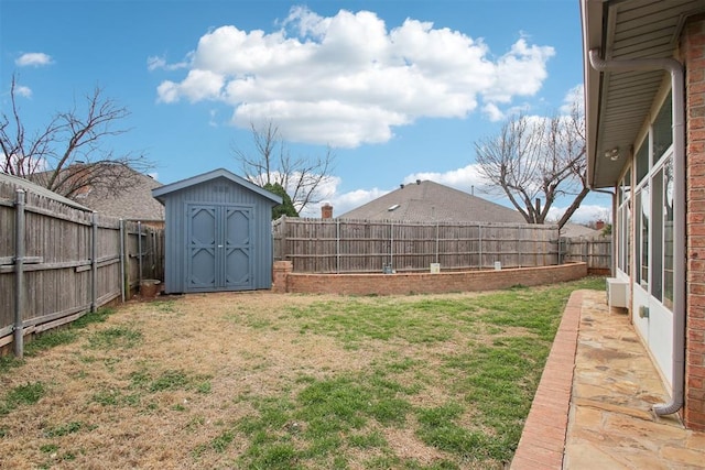 view of yard with an outbuilding, a fenced backyard, and a storage shed