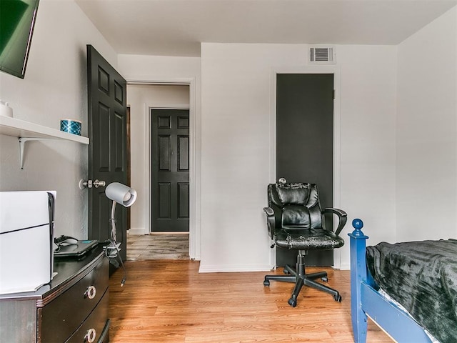 bedroom featuring visible vents, light wood-style flooring, and baseboards