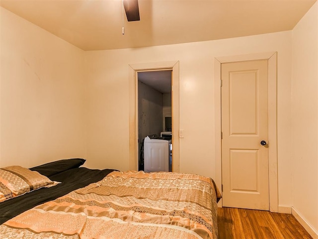 bedroom featuring a ceiling fan, washer / clothes dryer, and wood finished floors