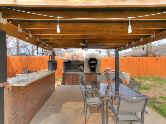 view of patio featuring ceiling fan, outdoor dining space, a fenced backyard, and washer / dryer