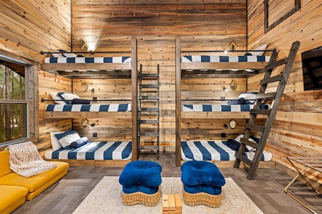 bedroom with carpet flooring, wood walls, and a towering ceiling