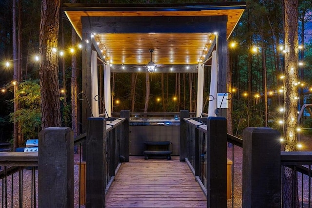 patio at night featuring a hot tub