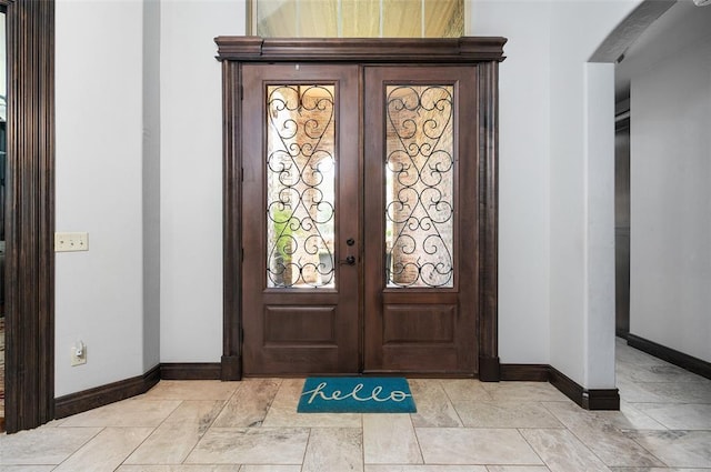 foyer entrance featuring french doors and baseboards