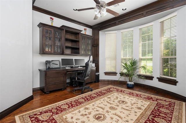 home office featuring ceiling fan, dark wood-style flooring, visible vents, baseboards, and crown molding