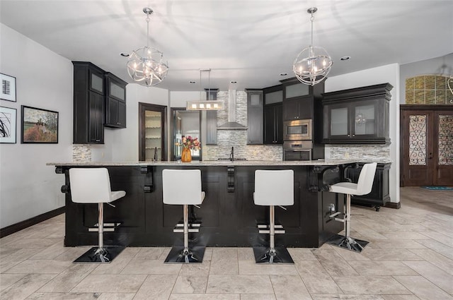 kitchen featuring wall chimney exhaust hood, a sink, light countertops, and stainless steel appliances