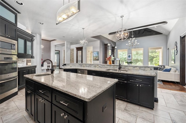 kitchen with dark cabinetry, a sink, and a large island