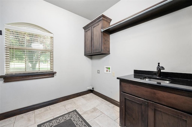 laundry room featuring hookup for a washing machine, cabinet space, a sink, and baseboards