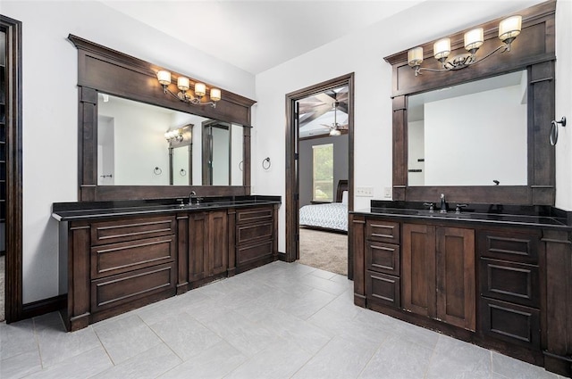 bathroom featuring a ceiling fan, two vanities, and a sink