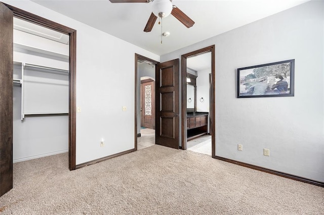 unfurnished bedroom with carpet, baseboards, arched walkways, and a closet