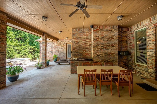 view of patio / terrace with outdoor dining area, a jacuzzi, and a ceiling fan