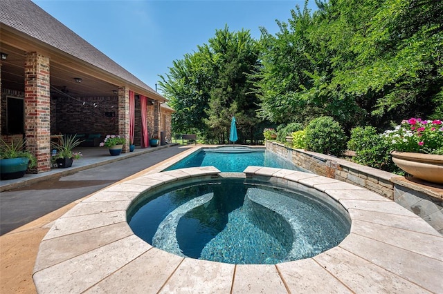 view of swimming pool featuring a pool with connected hot tub and a patio