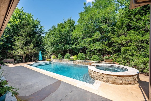 outdoor pool featuring an in ground hot tub and a patio