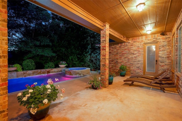 view of patio featuring an in ground hot tub and an outdoor pool