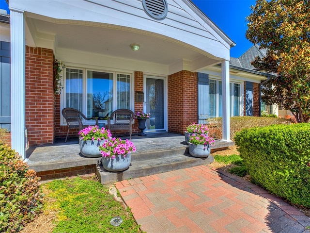 entrance to property with brick siding and covered porch