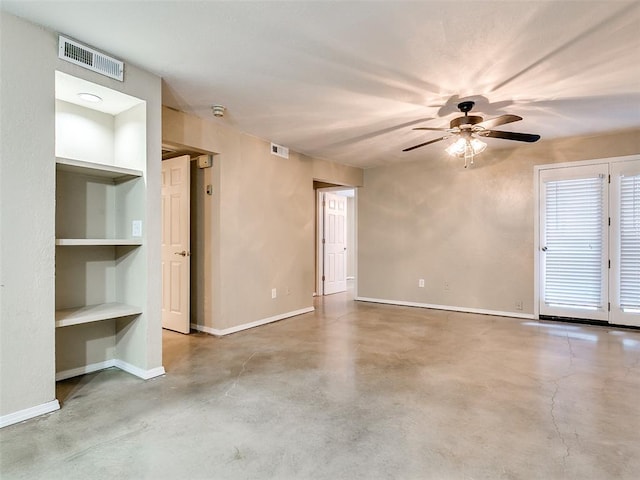 empty room featuring finished concrete flooring, baseboards, visible vents, and built in features