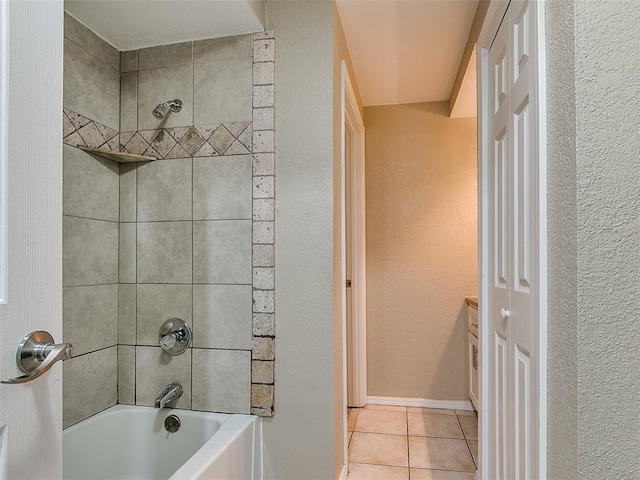 bathroom featuring a textured wall, tile patterned flooring, baseboards, and shower / bathtub combination