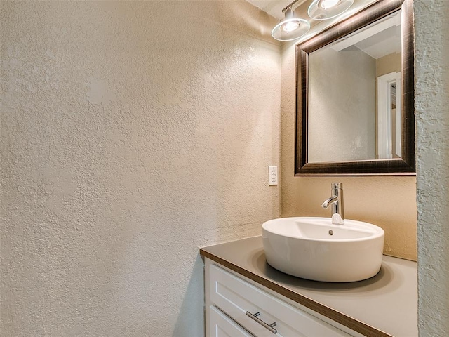bathroom with vanity and a textured wall
