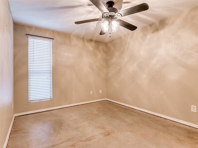 spare room with ceiling fan, concrete floors, and baseboards