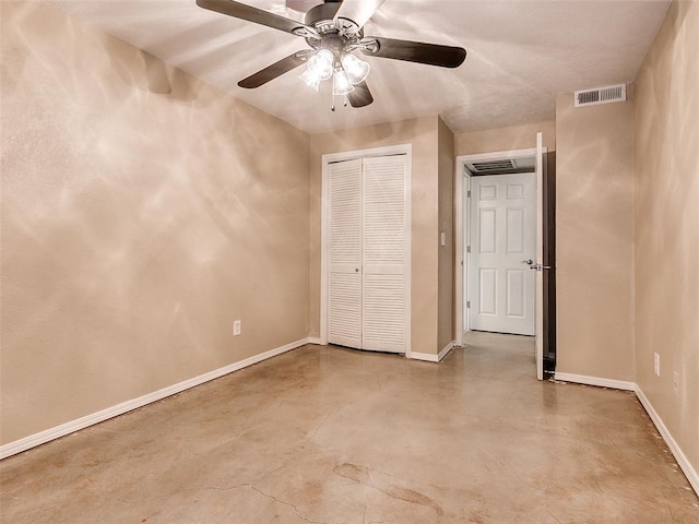 unfurnished bedroom featuring baseboards, concrete floors, visible vents, and a closet