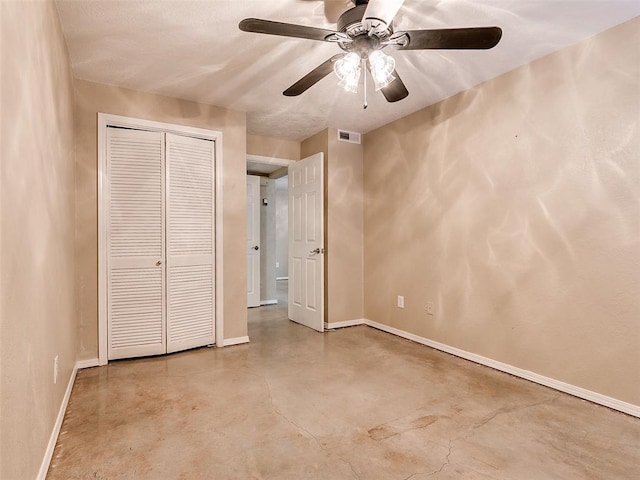 unfurnished bedroom with a closet, visible vents, a ceiling fan, concrete flooring, and baseboards