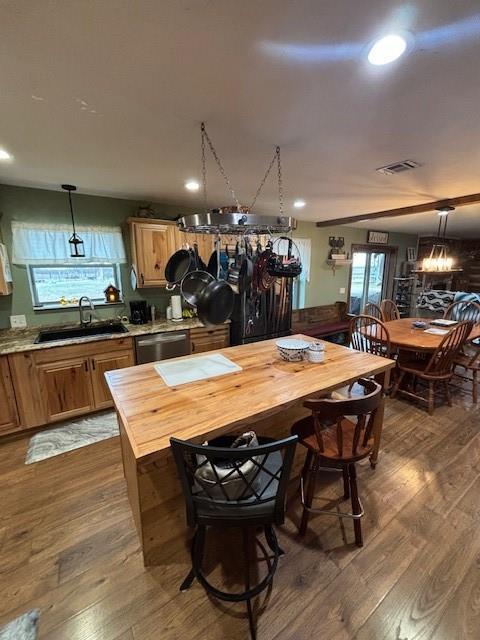 kitchen with visible vents, a sink, dark wood finished floors, wood counters, and stainless steel dishwasher