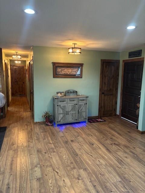 hall featuring recessed lighting, baseboards, and wood finished floors