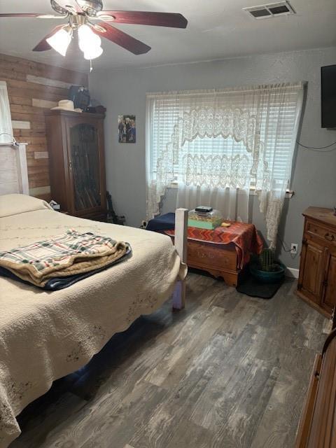 bedroom featuring ceiling fan, visible vents, and wood finished floors