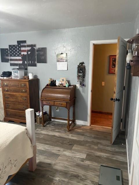 bedroom featuring wood finished floors and baseboards