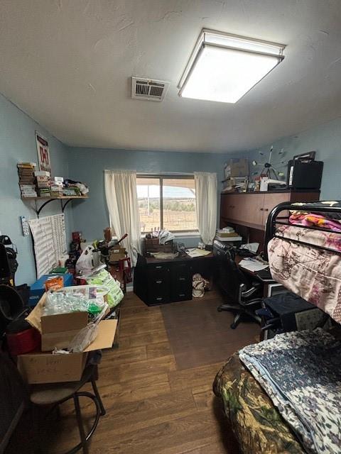 bedroom featuring visible vents and wood finished floors