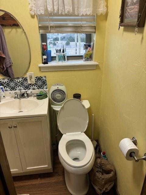 bathroom featuring vanity, toilet, and wood finished floors