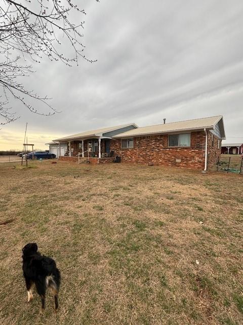 exterior space with brick siding and a yard