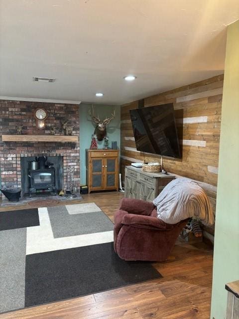 354504 E 980th Rd, Prague, OK 74864 - living room featuring wooden walls, a wood stove, wood finished floors, and recessed lighting
