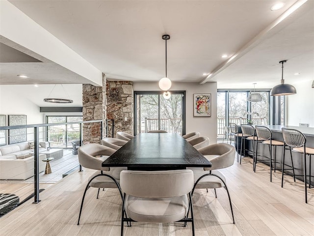 dining room with recessed lighting, beam ceiling, and light wood finished floors