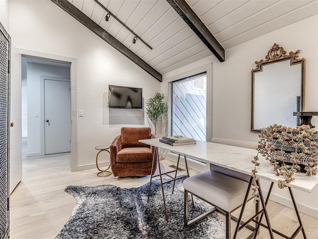 interior space with rail lighting, vaulted ceiling with beams, wood finished floors, and baseboards