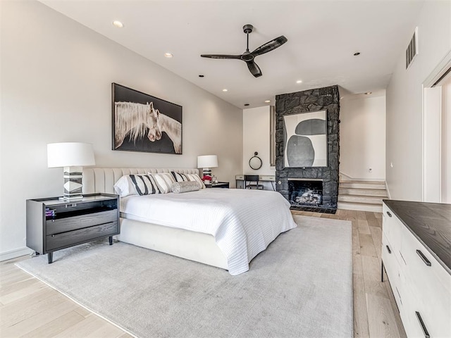 bedroom featuring visible vents, recessed lighting, light wood-style floors, a fireplace, and ceiling fan