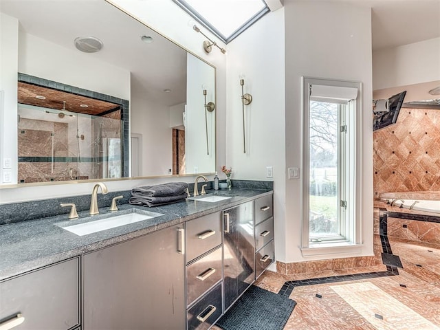 bathroom with a sink, double vanity, a skylight, and a shower stall