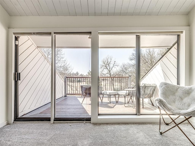 entryway with a healthy amount of sunlight, wooden ceiling, and carpet flooring